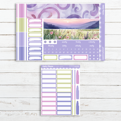 a purple and green planner sticker next to a white wooden background